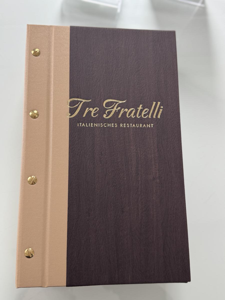 Hochformatige zweifarbige Speisekartenmappe des Ristorante Tre Fratelli in Beige und Holzoptik mit Goldprägung
