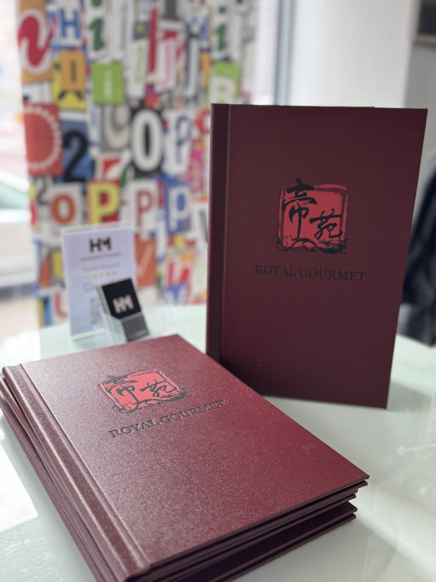 Bordeauxrote Speisekartenmappen des Restaurants Royal Gourmet, gestapelt und aufgestellt