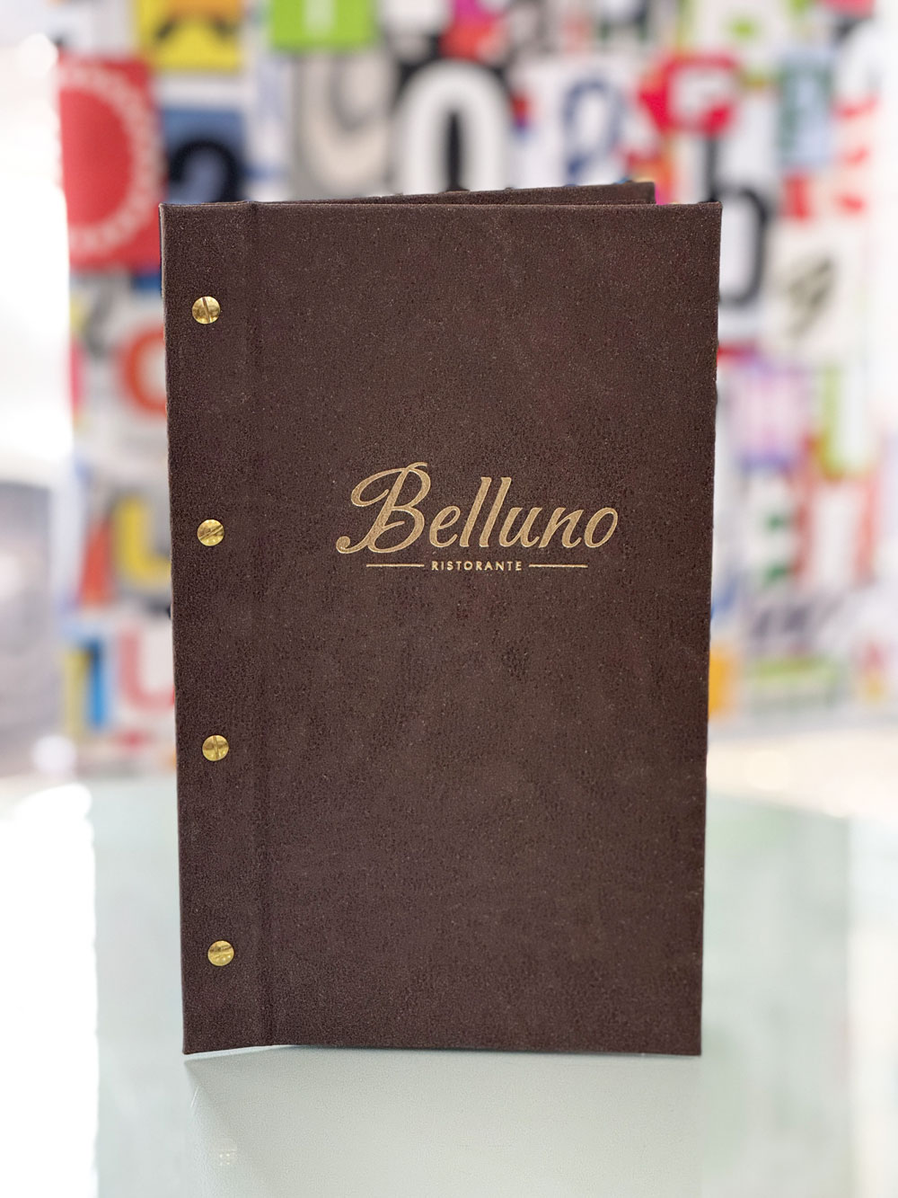 Speisekartenmappe aus dunkelbraunem Velours mit goldener Logo-Prägung für das Ristorante Belluno