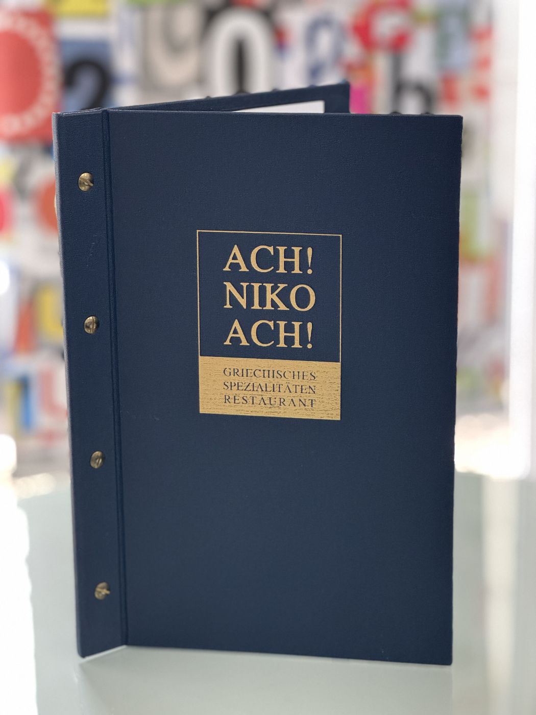 Restaurant Ach Niko Ach - Blaue Speisekarte mit Goldprägung